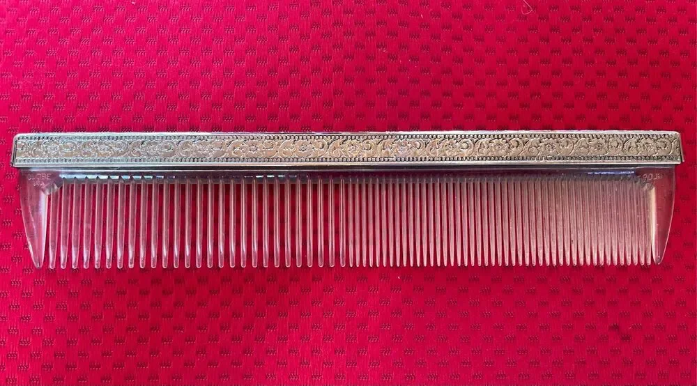 Vintage Globe USA plastic hair comb featuring an ornate, embossed metal spine co